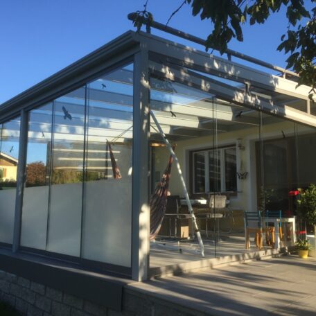 Modernes Terrassendach aus Glas und Metall an Wohnhaus, Sitzbereich und Leiter sichtbar. HANSEL.kraus metalltechnik gmbh