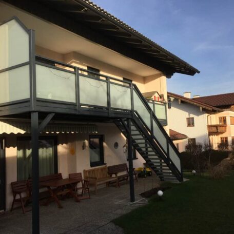 Zweistöckiges Wohnhaus mit Außentreppe und Balkon aus Glas in ruhigem Wohngebiet. HANSEL.kraus metalltechnik gmbh