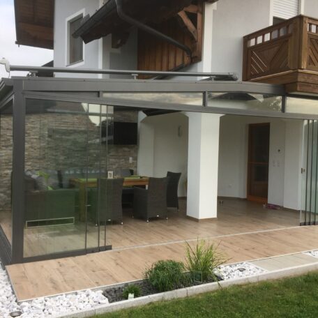 Überdachte Terrasse mit Glaselementen und Sitzgruppe an einem modernen Wohnhaus. HANSEL.kraus metalltechnik gmbh