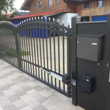 Elektrisches Hoftor mit Briefkasten vor einem Haus, moderne Toranlage mit Antrieb. HANSEL.kraus metalltechnik gmbh
