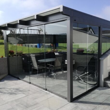 Moderne Terrassenüberdachung aus Glas mit Sitzbereich und weitem Blick ins Grüne. HANSEL.kraus metalltechnik gmbh
