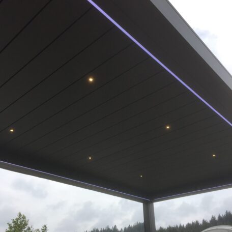 Modernes Terrassendach mit integrierten LED-Spots und dezenter Ambientebeleuchtung bei bewölktem Himmel. HANSEL.kraus metalltechnik gmbh