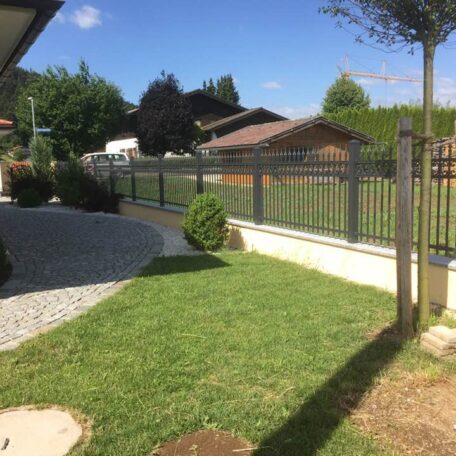 Gepflegter Garten mit Rasenfläche, Metalzzaun und Gartenhäusern, sonniger Tag, moderner Vorgarten. HANSEL.kraus metalltechnik gmbh