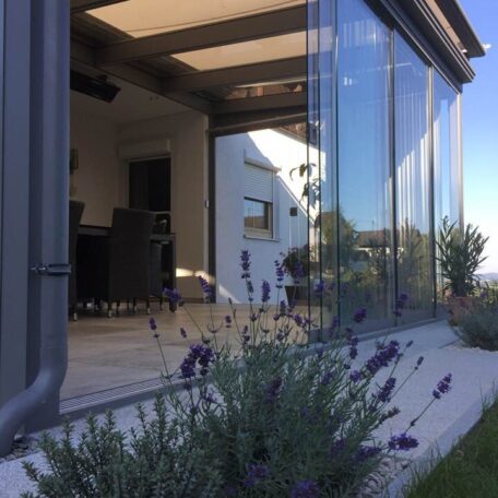 Modernes Wohnzimmer mit Glasfront und Lavendel im Garten, lichtdurchflutetes Ambiente. HANSEL.kraus metalltechnik gmbh