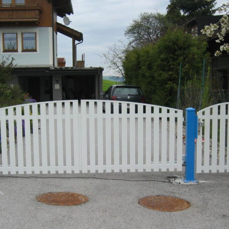 Weißer Holzzaun begrenzt Einfahrt zu Wohnhaus mit Auto im Hintergrund, Frühling. HANSEL.kraus metalltechnik gmbh