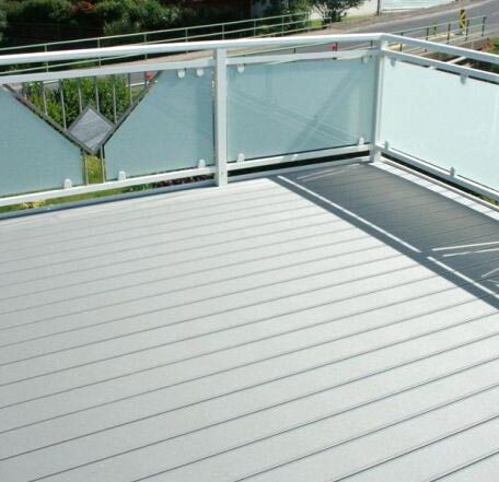 Barrierefreier Balkon mit modernen Glasgeländern und hellgrauem Boden, Ausblick ins Grüne. HANSEL.kraus metalltechnik gmbh