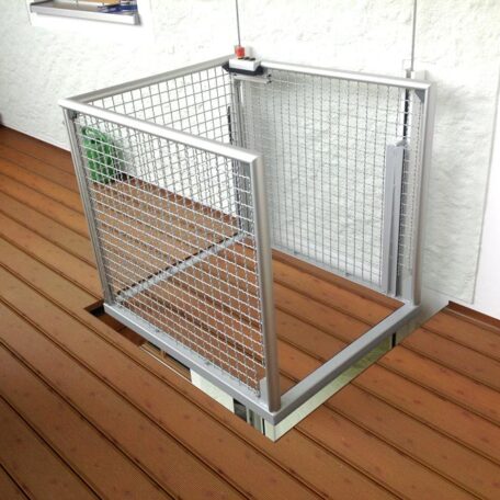 Kleiner offener Aufzug mit Metallgitter auf einer Holzterrasse für barrierefreien Zugang. de HANSEL.kraus metalltechnik gmbh