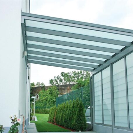 Modernes Glasvordach an Hausfassade mit angrenzendem Garten und Sichtschutz. HANSEL.kraus metalltechnik gmbh
