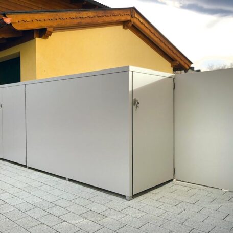 drei silbergraue Mülltonnenboxen aus Metall auf gepflasterter Terrasse, Gebäude im Hintergrund HANSEL.kraus metalltechnik gmbh
