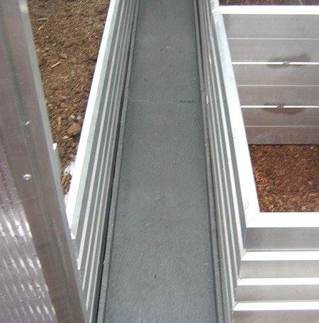 Hochbeet aus Aluminium mit schmalem Betonweg in einem Garten, erhöhte Beetumrandung. de HANSEL.kraus metalltechnik gmbh