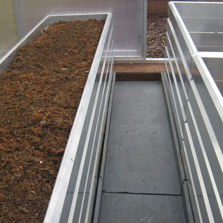 Zwei Hochbeete aus Metall mit Erde stehen nebeneinander in einem Gewächshaus. de HANSEL.kraus metalltechnik gmbh