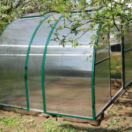 Gewächshaus mit grünem Rahmen steht im Garten unter einem Baum auf einer Rasenfläche. HANSEL.kraus metalltechnik gmbh
