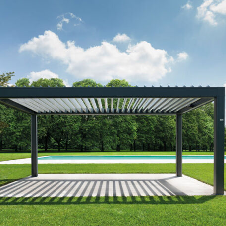 Moderne Pergola aus Metall steht auf Rasenfläche vor Pool und Bäumen bei Sonnenschein. HANSEL.kraus metalltechnik gmbh