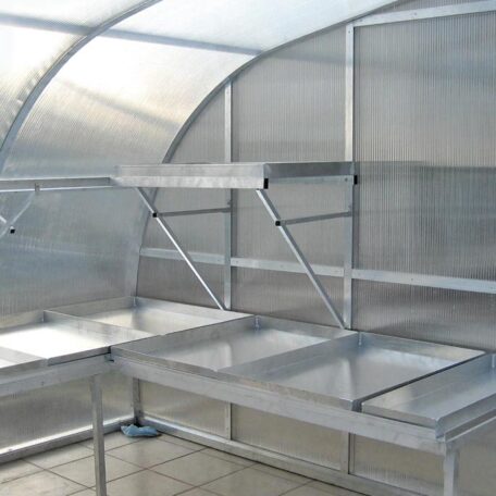 Metalltisch und Regal im Inneren eines Gewächshauses mit lichtdurchlässigen Wänden. HANSEL.kraus metalltechnik gmbh