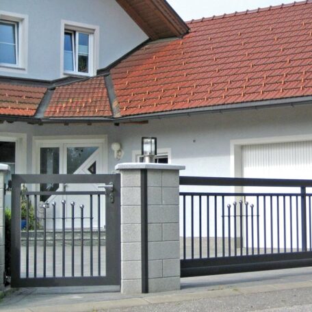 Modernes Einfamilienhaus mit elektrischem Hoftor und rotem Ziegeldach, Einfahrt geschlossen. HANSEL.kraus metalltechnik gmbh