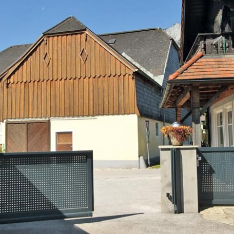 Großer Bauernhof mit Scheune, Tor und modernisiertem Wohnhaus bei sonnigem Wetter. HANSEL.kraus metalltechnik gmbh