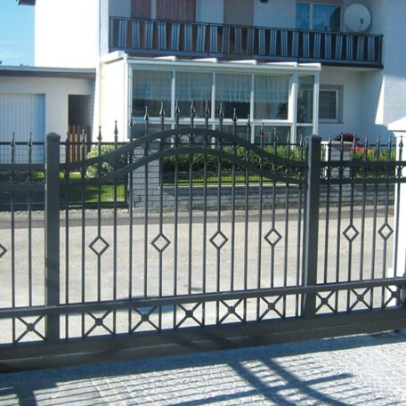 Schmiedeeisernes Gartentor mit Verzierungen vor einem modernen Wohnhaus. HANSEL.kraus metalltechnik gmbh