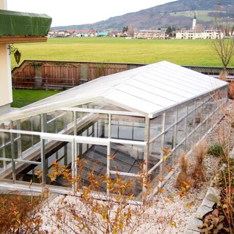 Großes Gewächshaus aus Glas mit Blick auf eine ländliche Landschaft im Hintergrund. HANSEL.kraus metalltechnik gmbh