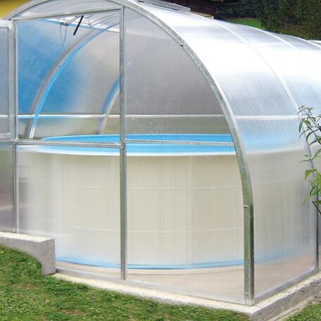 Ein rundes Aufstellbecken steht geschützt unter einer transparenten Poolüberdachung im Garten. HANSEL.kraus metalltechnik gmbh