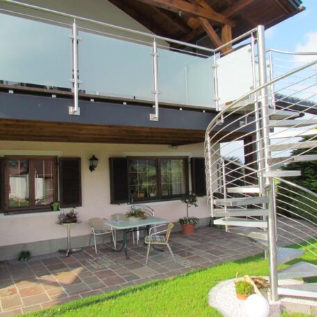 Überdachte Terrasse mit Sitzgruppe und Wendeltreppe im Garten eines Einfamilienhauses. HANSEL.kraus metalltechnik gmbh
