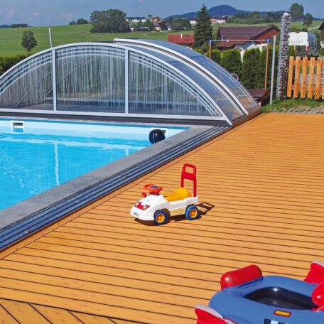 Kinderspielzeug und Pool mit Schiebedach auf Terrasse vor ländlicher Kulisse, Sommerlandschaft. HANSEL.kraus metalltechnik gmbh