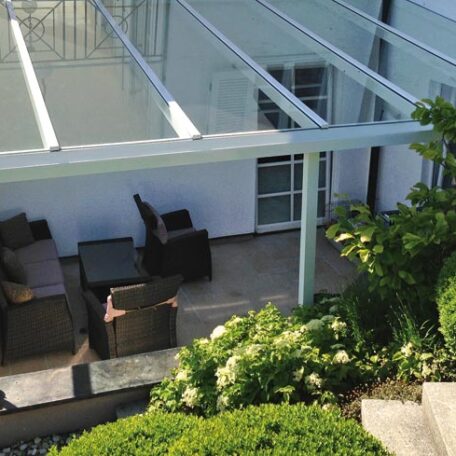 Überdachte Terrasse mit Sitzgruppe und Gartenpflanzen an einem modernen Wohnhaus. HANSEL.kraus metalltechnik gmbh