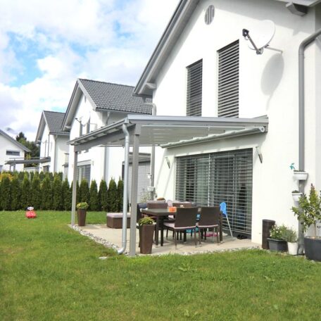 Moderne Terrasse mit Glasüberdachung, Gartenmöbeln und Rasen an Einfamilienhaus bei Freiburg. HANSEL.kraus metalltechnik gmbh