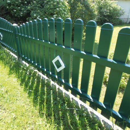 Grüner Holzzaun mit Ziersprosse im Garten, Sonne wirft Schatten auf das Gras. de HANSEL.kraus metalltechnik gmbh