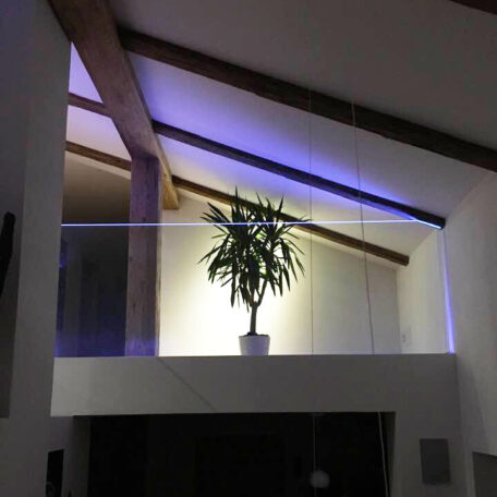 Pflanze im weißen Topf steht auf Galerie mit moderner Glasbrüstung und LED-Beleuchtung. HANSEL.kraus metalltechnik gmbh