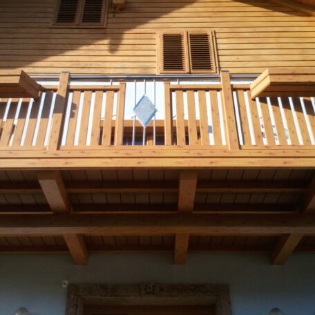 Holzbalkon eines Chalets mit Handtuch an der Brüstung und Sonnenlicht auf der Fassade. HANSEL.kraus metalltechnik gmbh