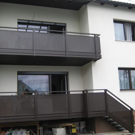 Zwei Balkone mit dunklem Geländer an weißem Mehrfamilienhaus, Außentreppe führt zum unteren Balkon. de HANSEL.kraus metalltechnik gmbh