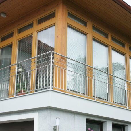 Großer Wintergarten mit bodentiefen Fenstern und Metallgeländer an einem modernen Haus. HANSEL.kraus metalltechnik gmbh
