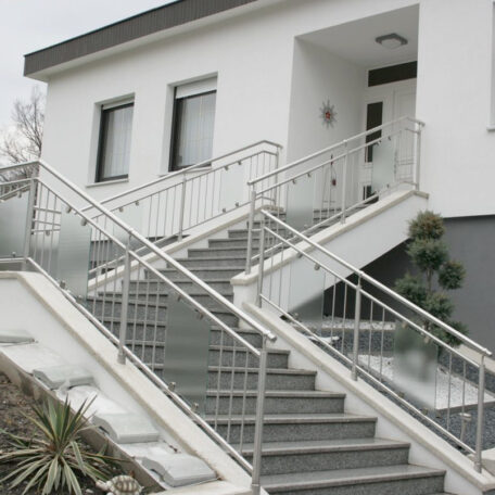 Treppenaufgang mit Edelstahlgeländer vor modernem, weißem Wohnhaus, Pflanzen am Rand. de HANSEL.kraus metalltechnik gmbh