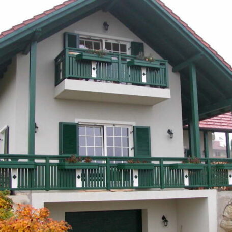 Einfamilienhaus mit grünem Balkon, grünen Fensterläden und weißer Fassade im traditionellen Stil. HANSEL.kraus metalltechnik gmbh