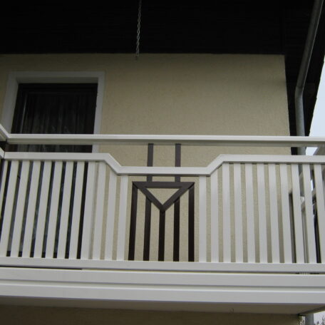 Balkon mit weißem Geländer und verglaster Tür an beiger Hausfassade. de HANSEL.kraus metalltechnik gmbh