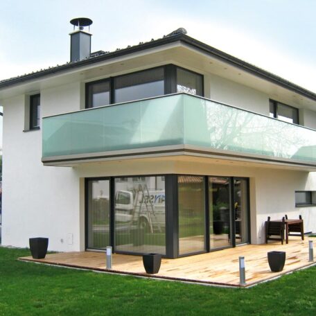 Modernes Einfamilienhaus mit großer Glasfassade, Balkon und Terrasse auf gepflegtem Rasen. HANSEL.kraus metalltechnik gmbh