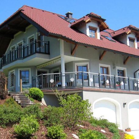Modernes Einfamilienhaus mit Balkon, großen Fenstern und gepflegtem Garten an Hanglage. HANSEL.kraus metalltechnik gmbh