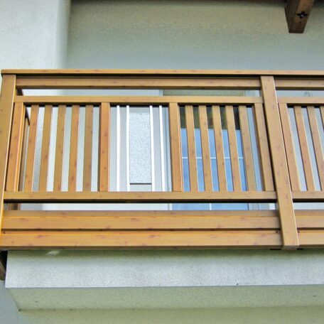 Holzbalkon mit senkrechten Streben und integriertem Sichtschutz-Element an Hausfassade. de HANSEL.kraus metalltechnik gmbh