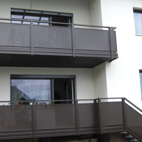 Zwei moderne Balkone mit braunen Geländern an einem weißen Mehrfamilienhaus. HANSEL.kraus metalltechnik gmbh