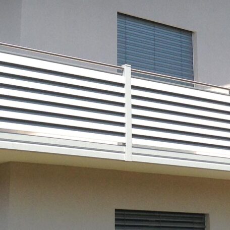 Moderner Balkon mit horizontalen weißen Streben und geschlossenem Fenster an grauer Fassade. HANSEL.kraus metalltechnik gmbh