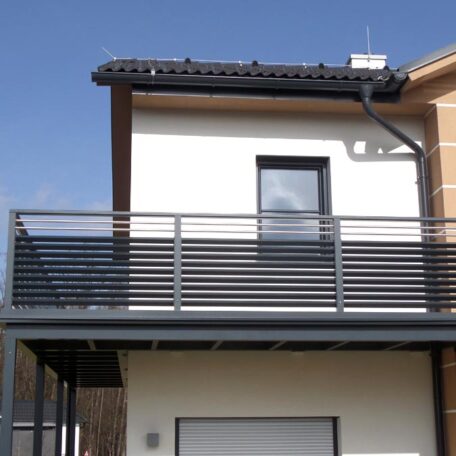 Moderner Balkon mit grauem Metallgeländer an Einfamilienhaus vor blauem Himmel. de HANSEL.kraus metalltechnik gmbh