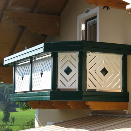 Balkon mit grün-weißer Holzverkleidung, traditionelles Design, angebracht an einem Haus im Landhausstil. HANSEL.kraus metalltechnik gmbh
