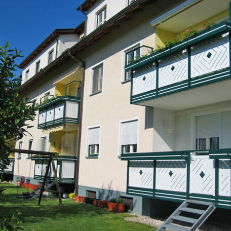 Mehrfamilienhaus mit Balkonen, Gartenbereich und Schaukel, sonniger Tag in Freiburg. HANSEL.kraus metalltechnik gmbh