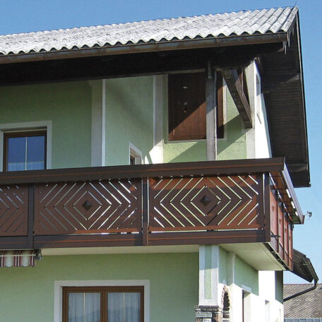Obergeschoss mit grün gestrichener Fassade und dekorativem Holz-Balkon an Einfamilienhaus. HANSEL.kraus metalltechnik gmbh