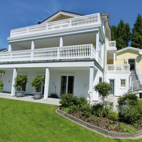Elegante weiße Villa mit Balkonen, gepflegtem Garten und Treppe an sonnigem Tag. HANSEL.kraus metalltechnik gmbh