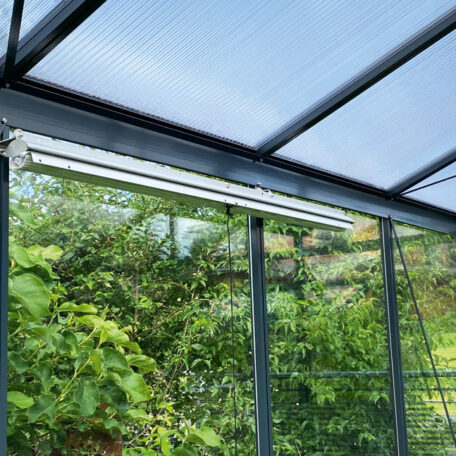 Gewächshaus mit Polycarbonatdach und grüner Bepflanzung, Tageslichtfilterung im Fokus. HANSEL.kraus metalltechnik gmbh