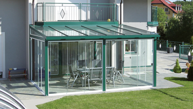 Glasüberdachte Terrasse mit Gartenblick und Sitzgruppe, moderne Terrassenüberdachung für gemütliche Stunden. HANSEL.kraus metalltechnik gmbh
