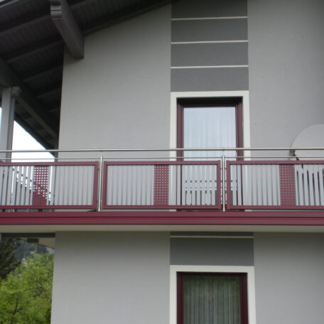 Moderner Balkon mit rot-grauem Geländer an einem Einfamilienhaus in Freiburg. HANSEL.kraus metalltechnik gmbh