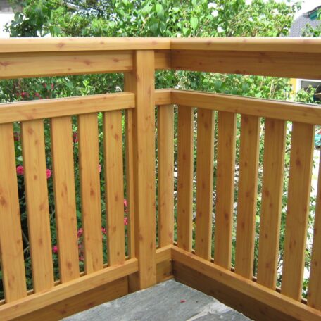 Holzgeländer mit senkrechten Latten auf Balkon, Hintergrund aus Bäumen. HANSEL.kraus metalltechnik gmbh