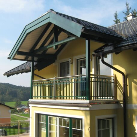 Balkon mit grünem Geländer und Dach an gelbem Haus im ländlichen Freiburg. HANSEL.kraus metalltechnik gmbh